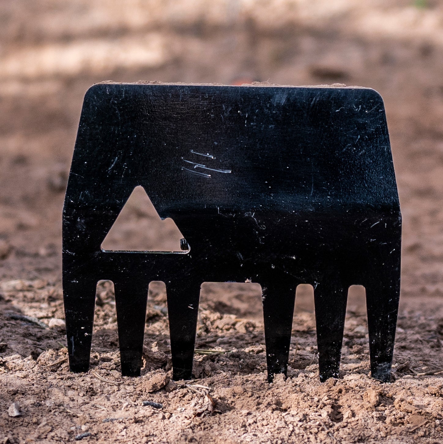 A black silhouette of the Clyde, a hoe and rake tool with a rectangular head and a fiberglass handle.